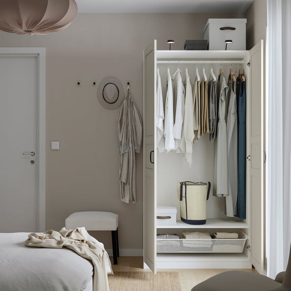 Open wardrobe showing clothes, boxes, and storage. Adjustable feet, integrated dampers on hinges, and interior organizers visible.
