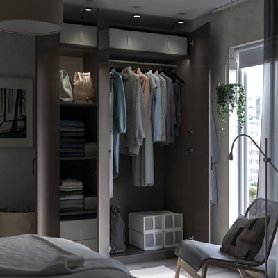 Modern dark-colored walk-in closet with clothes, shelves, and storage boxes. A hanging rack, organised shelves, and a sleek design.