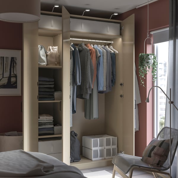 Modern walk-in closet with clothing, hanging bags, and storage boxes.