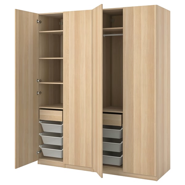 A light-colored wooden PAX wardrobe with open sections revealing shelves, drawers, and storage baskets.