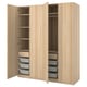 A light-colored wooden PAX wardrobe with open sections revealing shelves, drawers, and storage baskets.