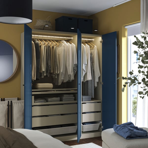 Blue wardrobe with clothes, drawers, and lights inside. Wall-fixed for stability.