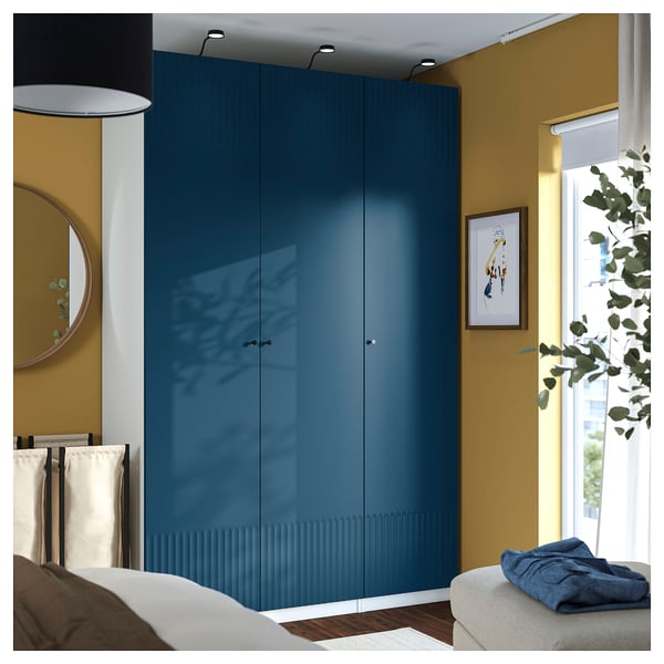Blue PAX wardrobe with 3 mirrors, beside bed, mustard walls, includes storage basket.