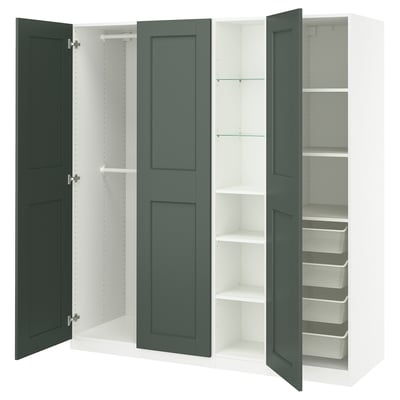 An open, dark green PAX wardrobe with multiple storage compartments, including shelves and a clothes rail.