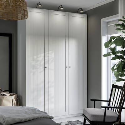 PAX wardrobe with inset lights, minimalist design next to window.