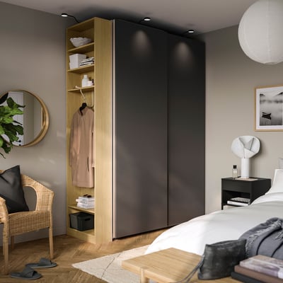 Modern bedroom with wall-mounted PAX wardrobe, bed, and decor.