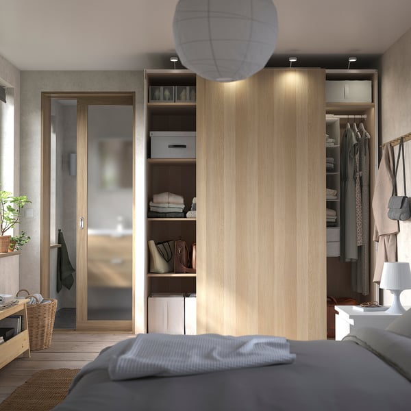 Modern bedroom with wooden PAX wardrobe and cosy bed.