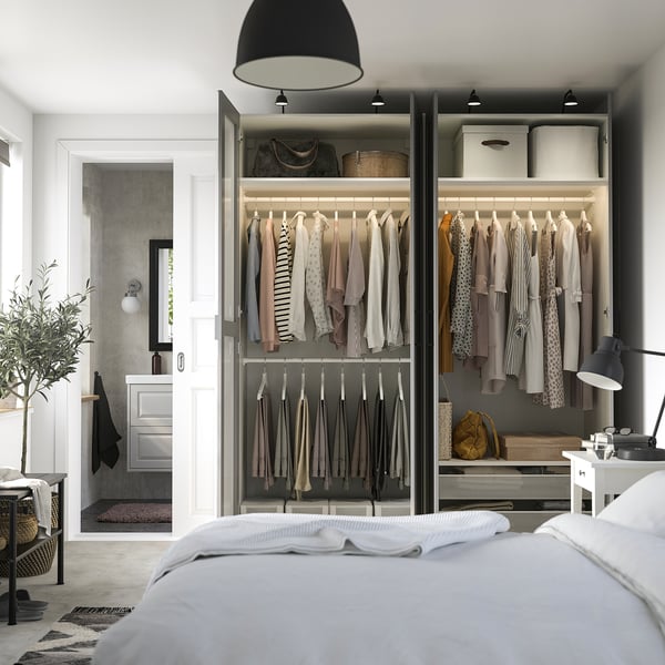Modern open closet displays clothes, with organised shelves and hanging space. .