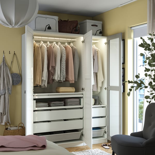Well-organized wardrobe with clothes, drawers, and storage boxes. Mirrored doors and built-in lighting.