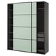 A modern PAX wardrobe with green sliding doors and black interiors.