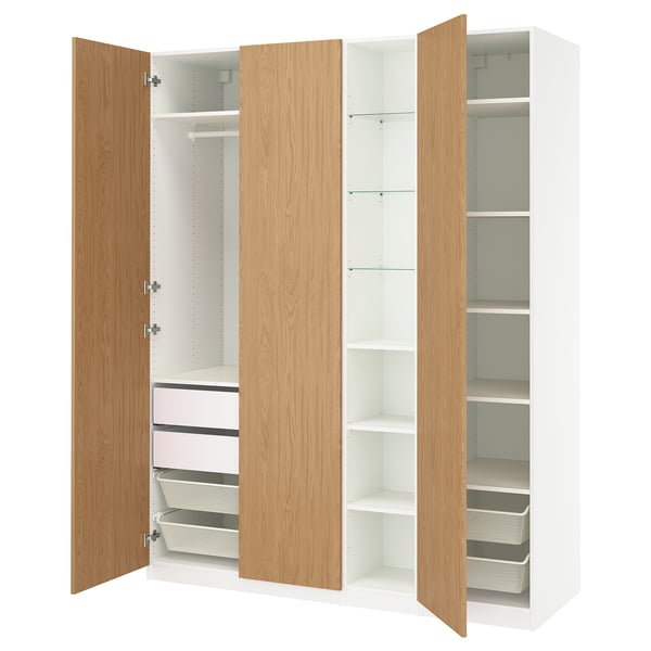An open IKEA PAX wardrobe with light oak doors, white interiors, shelves, and drawers.