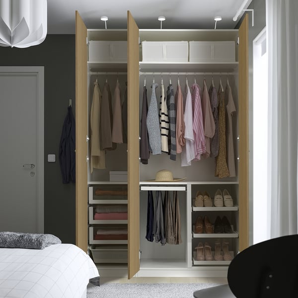 Open wooden wardrobe showing clothes, shoes, and drawers. Three sections: hangers, drawers, storage.