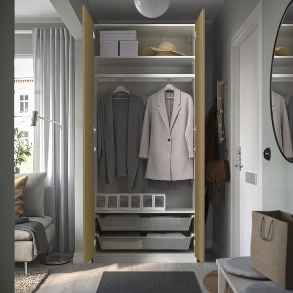 Open wooden closet showcasing organised clothes and storage bins, reflecting efficient space use and neat arrangement.