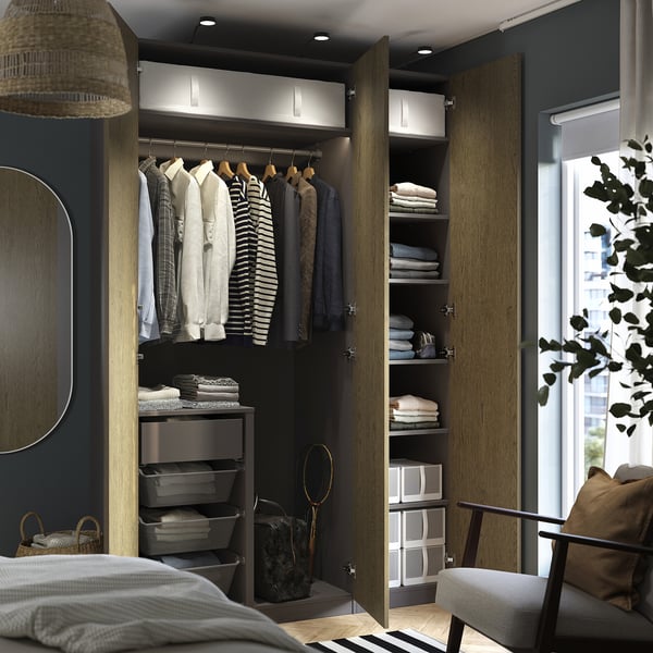 Organised closet with hanging shirts, folded clothes, and storage bins, featuring integrated lighting and adjustable shelving.