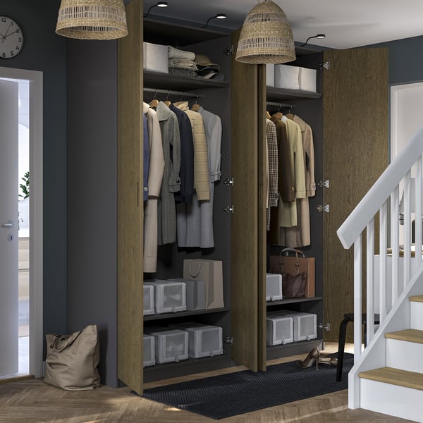 Modern wardrobe with clothes, shelves, and lamps. Stairway and clock to right.
