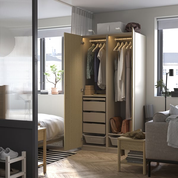 Open wardrobe with clothes, drawers, and lighting. Integrated handle and adjustable feet visible.