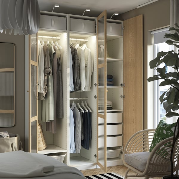 Modern wardrobe with interior lights, organised clothes, and mesh baskets.