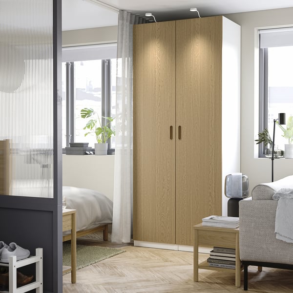 Large wooden PAX wardrobe in room, surrounded by smaller furniture.