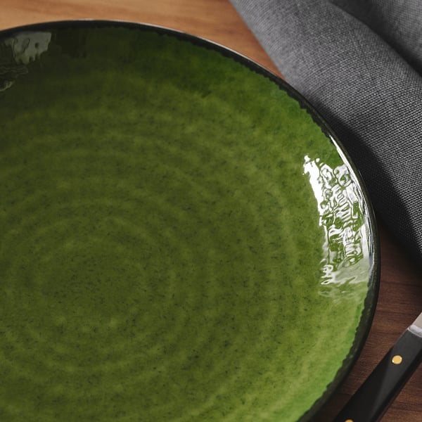 Elongated green plate on table, glossy finish, deeper centre, darker rim.