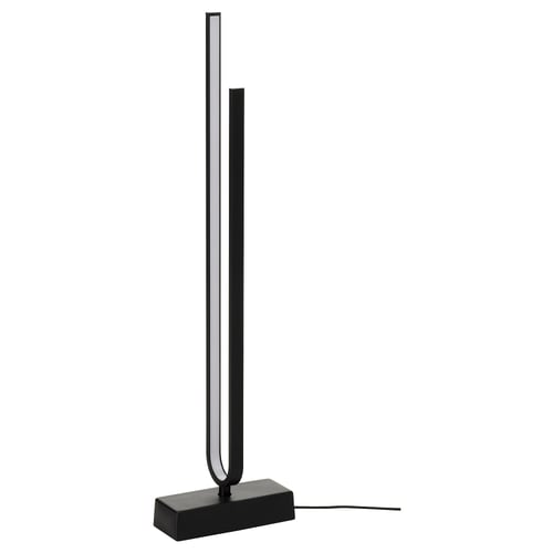 The PILSKOTT lamp in black, featuring a sleek, curved design with a concrete base and metallic finish.