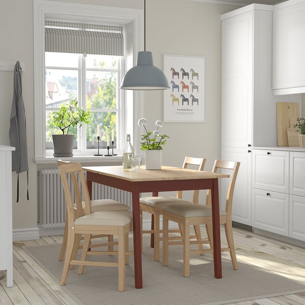 Cosy dining setup with PINNTORP table, chairs, and blue pendant light. Kitchen window and plant add natural light and greenery.