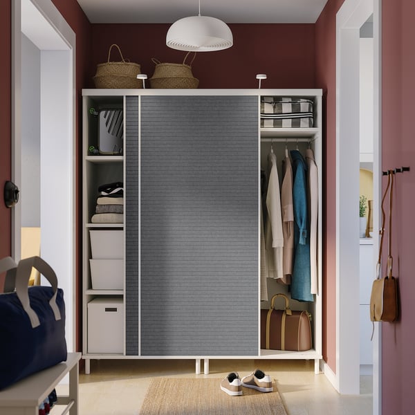 Modern closet with sliding doors, featuring organised clothes, storage boxes, and hanging bags, space-efficient with adjustable feet.