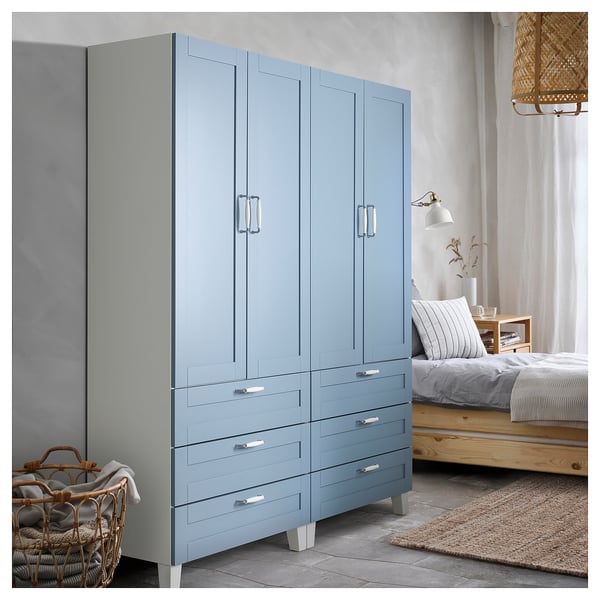Large blue wardrobe with handles. Four drawers, two doors. Modern bedroom setup.