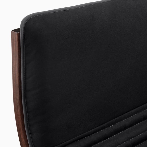 Black fabric POÄNG chair, showcasing high-quality stitching and curved wooden backrest.