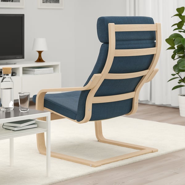 Blue armchair with wooden frame, cushioned seat and back, placed near a small table.