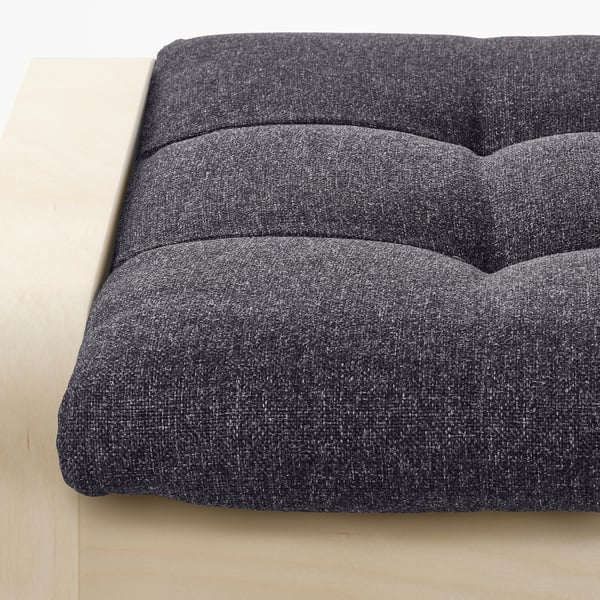 Close-up of a modern, cushioned footstool with a sturdy frame and tufted design, ideal for relaxation.