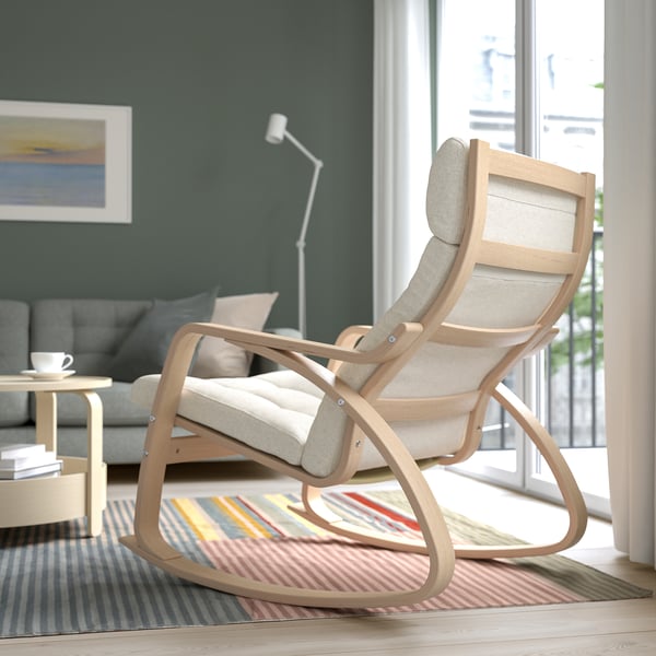 Wooden rocking chair with cushion, on rug in cosy living room.