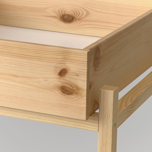 A close-up of a light wood furniture item, showing smooth grain and finish, highlighting its natural texture and sturdy construction.