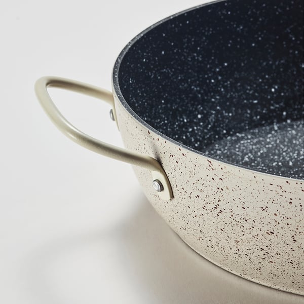 Modern non-stick cookware with speckled interior, robust tan handle, ideal for even cooking.