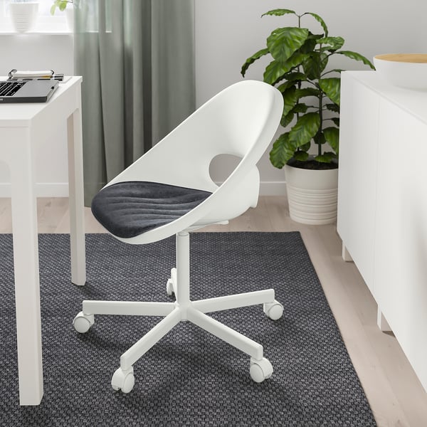 Modern office setup with white chair, grey seat pad, wooden desk, plant, and cabinet. Chair fits under desk.