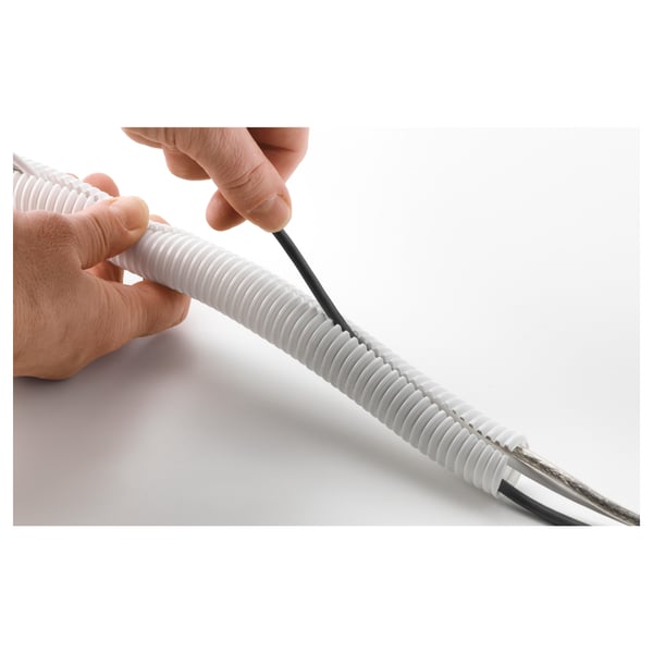 Hand holding white cable tidy wrapped around black cable, demonstrating how to keep cables organised and clean.