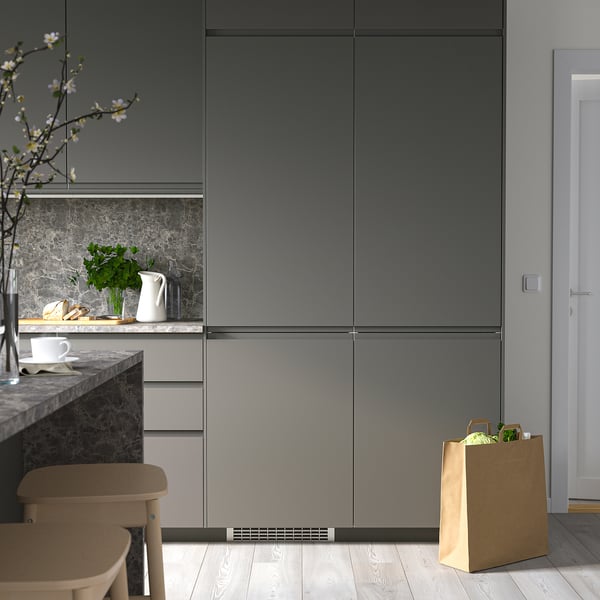 Modern kitchen with sleek, tall grey RÅKALL fridge/freezer. Minimalist design, clean aesthetic.