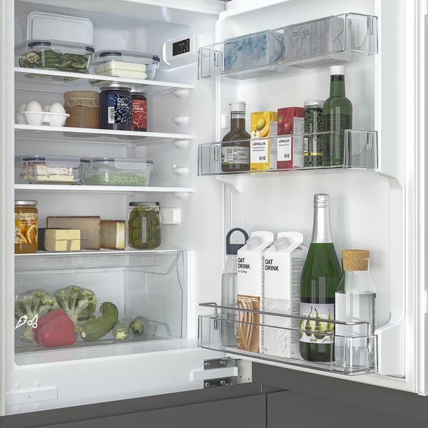 Well-organized fridge shelves with adjustable compartments, clear containers, and various food items. Includes glass shelves and led lighting.