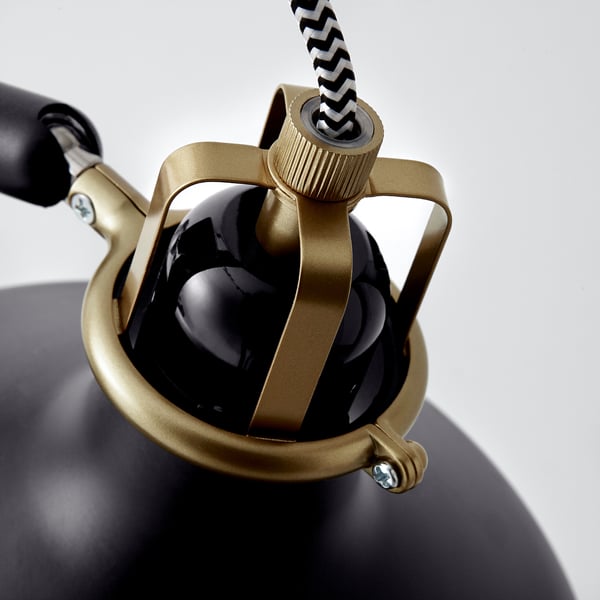 Close-up of RANARP lamp, gold and black, adjustable joint, texture details.