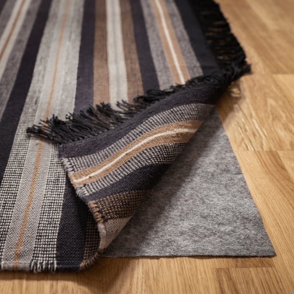 Striped wool rug on wooden floor, reversible, handwoven, flat weave.