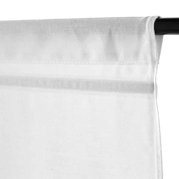 White RINGBLOMMA roman blind, partially raised by magnets, mounted on curtain rod.