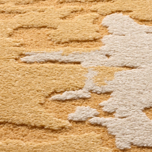 Abstract yellow and white patterned rug, high and low piles create a 3d texture.