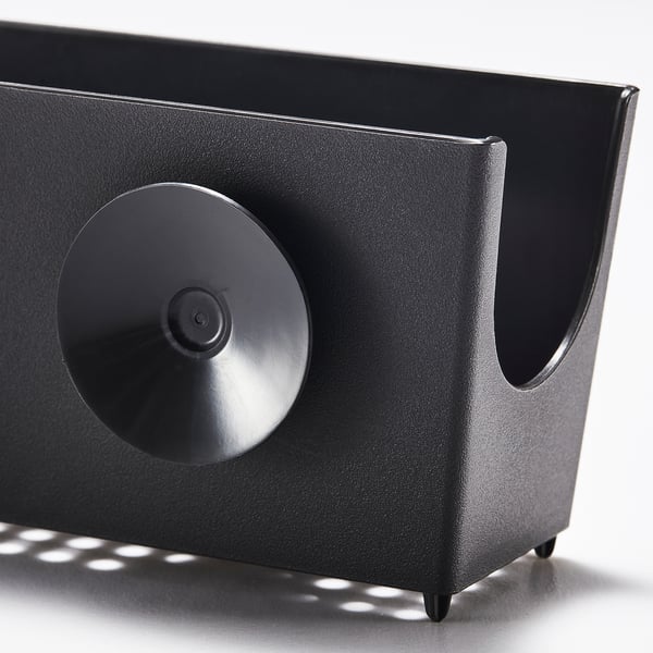 Black plastic sink caddy with suction cup, designed for holding sponges or brushes.