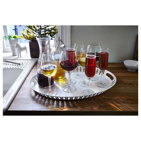 White tray with wine glasses and carafes on wooden surface.