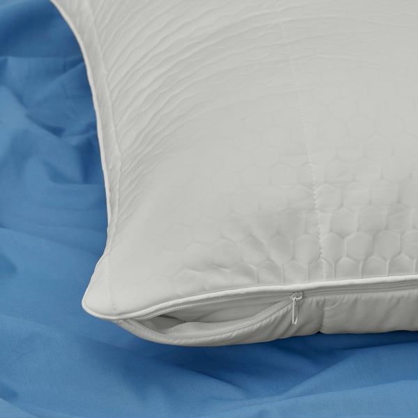 Comfortable pillow protector with zip, featuring a textured fabric for temperature regulation on a cosy blue bed.
