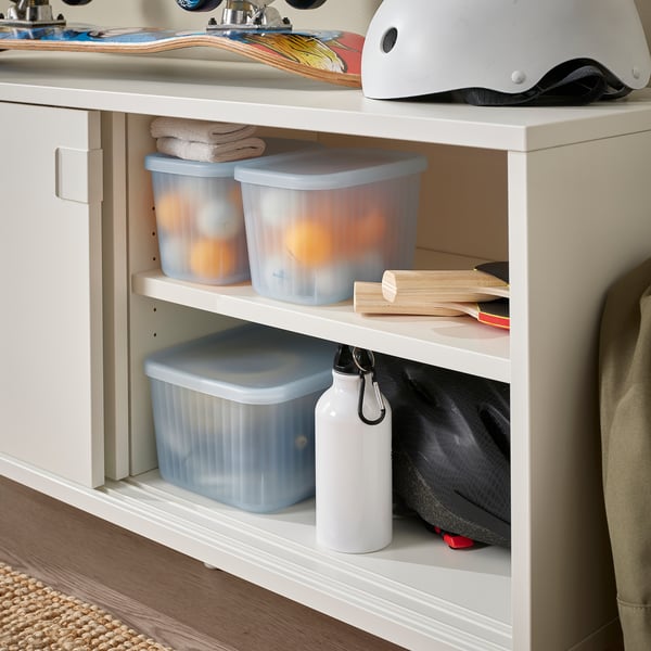 Clear storage boxes in a shelf organise small items in a bathroom.