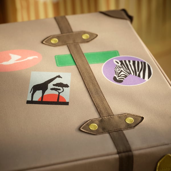 Decorative storage trunk with sturdy straps, vibrant stickers, and quality fabric, perfect for organising adventures.