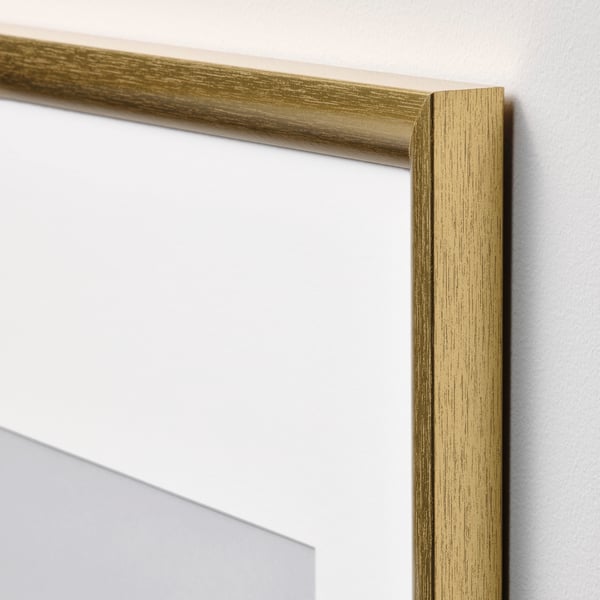 Gold picture frame with textured finish mounted on a white wall, showcasing high-quality craftsmanship and design.