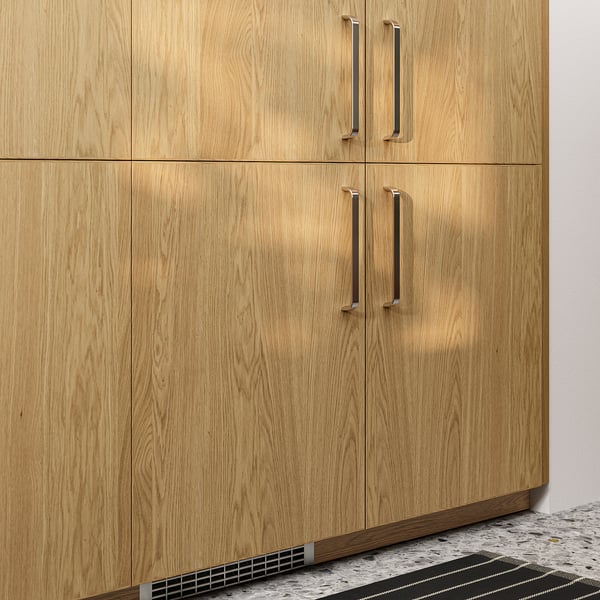 Natural light oak cabinets with gold handles, sleek and modern design, mounted on a patterned grey floor.