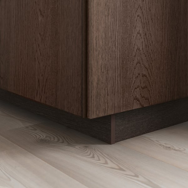 Dark wood cabinet with visible grain, solid oak edging on base, sits on light wooden floor, showcasing SINARP fronts elegance and detail.