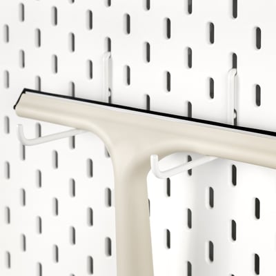 White SKÅDIS hook attached to pegboard; holds items securely.